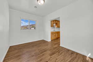 Empty room featuring baseboards, a sink, and dark wood-style flooring