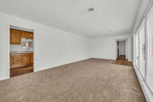 Interior space with baseboards, a sink, dark carpet, and multiple windows