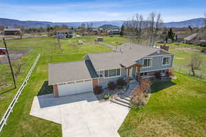 View of front of home with roof with shingles, driveway, brick siding, an attached garage, and board and batten siding