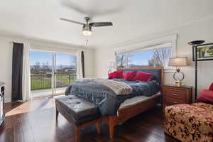 Bedroom featuring crown molding, dark wood-style flooring, access to outside, and multiple windows