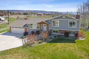 Split level home featuring brick siding, driveway, and fence