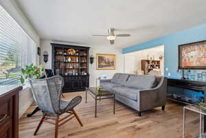 Living area with light wood-type flooring and ceiling fan