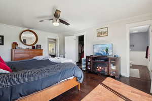 Bedroom with wainscoting, ensuite bath, wood finished floors, and a closet