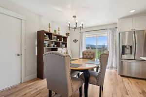 Dining area featuring baseboards, an inviting chandelier, light wood finished floors, and recessed lighting