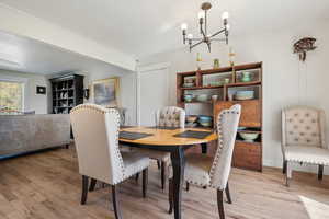 Dining area with a notable chandelier and light wood-style flooring