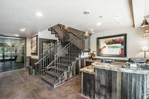 Staircase featuring recessed lighting, indoor bar, visible vents, and finished concrete floors