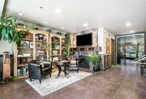Living room with a premium fireplace, a wainscoted wall, and recessed lighting