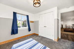 Bedroom featuring baseboards, a closet, and carpet