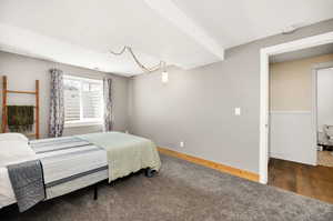 Carpeted bedroom with wood finished floors