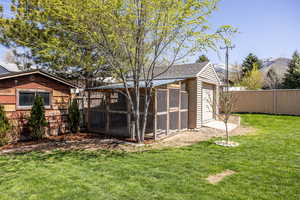 View of chicken coop with a yard and fence