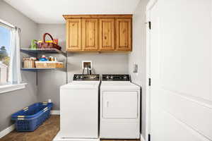 Laundry area featuring cabinet space, washing machine and clothes dryer, and baseboards
