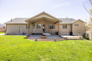 Back of house featuring a yard, fence, a patio area, and a shingled roof