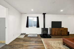 Living area with recessed lighting, a gas stove, and dark wood-style flooring