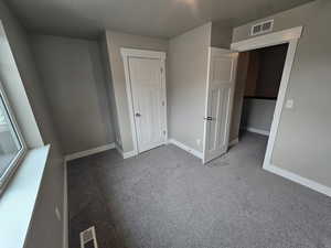 Unfurnished bedroom featuring baseboards, visible vents, and carpet flooring