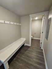 Mudroom with electric panel, baseboards, a textured ceiling, and dark wood-type flooring