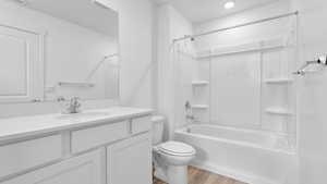 Bathroom with toilet, shower / bathing tub combination, recessed lighting, wood finished floors, and vanity