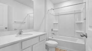 Full bathroom featuring wood finished floors, toilet, vanity, and shower / bathtub combination