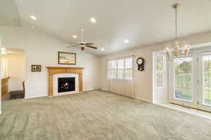Living room with plenty of natural light, cozy fireplace, and lofted ceiling