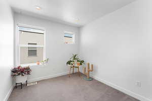Carpeted spare room with baseboards and recessed lighting