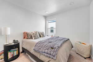 Bedroom featuring carpet and a textured ceiling