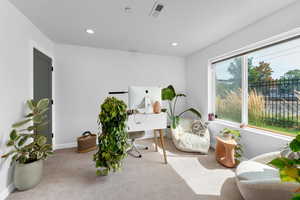 Office with carpet floors and recessed lighting