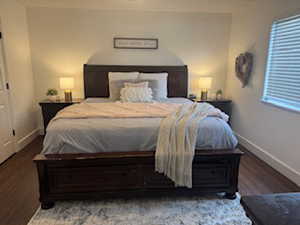 Bedroom featuring wood finished floors, baseboards, and multiple windows