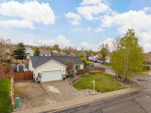 Single story home featuring concrete driveway, a residential view, a front yard, and a garage