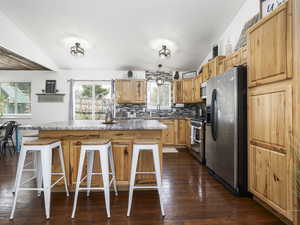 Kitchen featuring appliances with stainless steel finishes, tasteful backsplash, a sink, and a breakfast bar