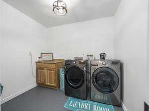Washroom with separate washer and dryer, baseboards, and cabinet space