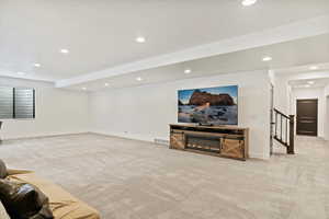 Unfurnished living room featuring light carpet, visible vents, and baseboards