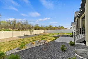 View of yard with a fenced backyard and a patio