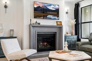Living area with a glass covered fireplace and wood finished floors