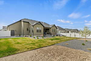 Back of property with a patio area, a lawn, a fenced backyard, and stucco siding