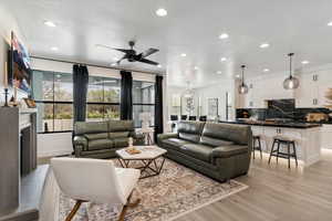 Living area with ceiling fan, light wood-style floors, and recessed lighting
