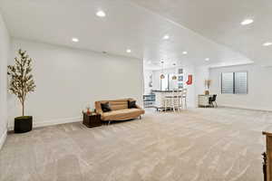 Sitting room featuring light carpet, baseboards, and recessed lighting