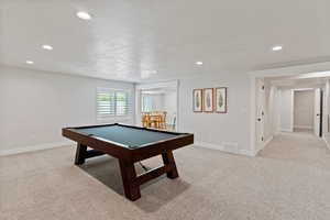 Rec room featuring light colored carpet, billiards, a textured ceiling, and visible vents