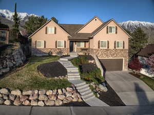 View of front of home with stucco siding, a mountain view, stairs, concrete driveway, and an attached garage