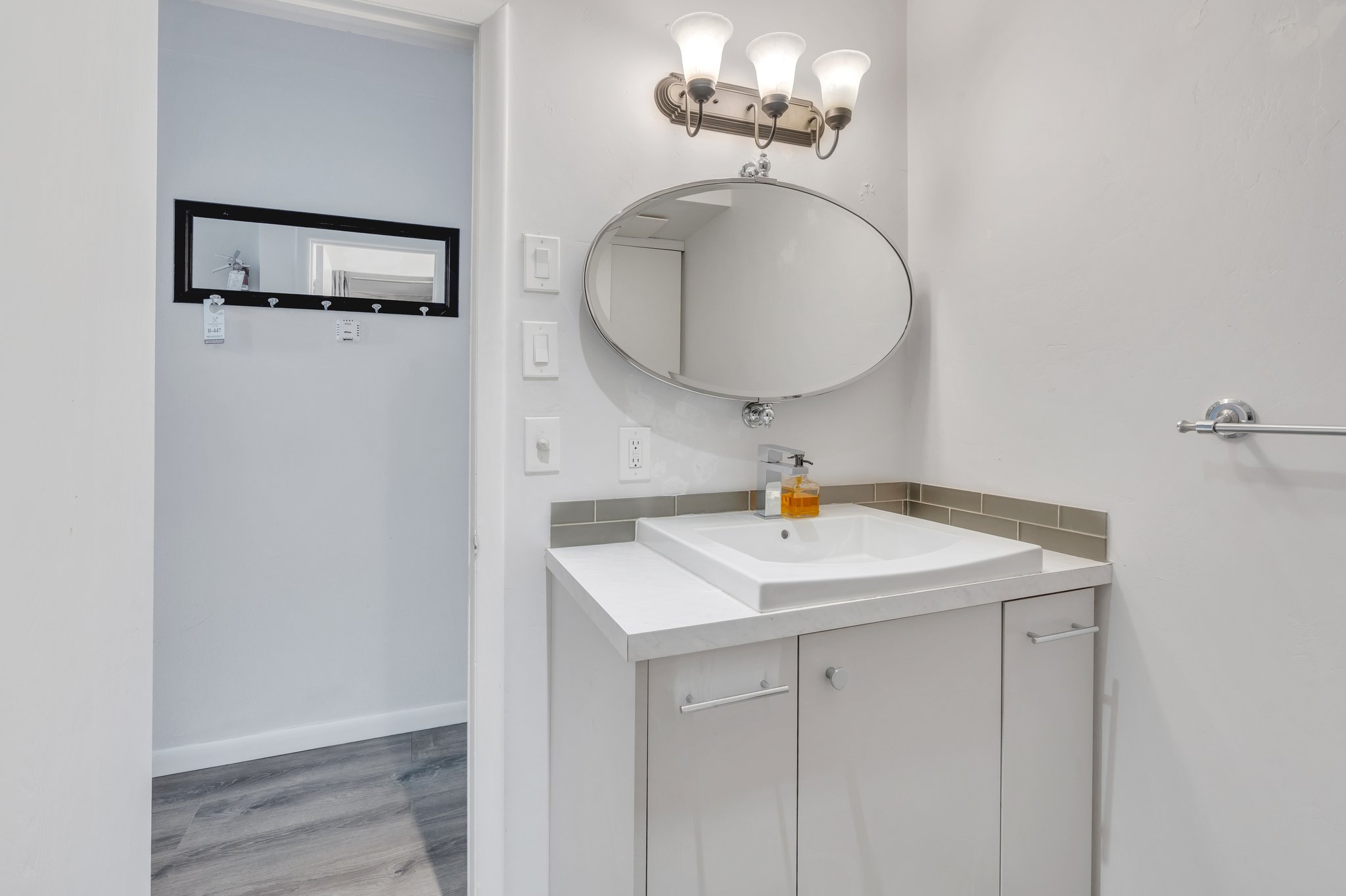 Bathroom featuring baseboards, wood finished floors, and vanity