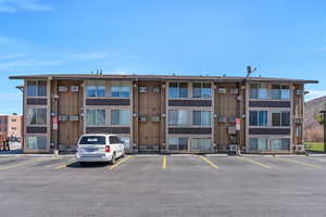 View of building exterior featuring uncovered parking