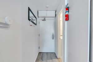 Corridor with light wood-style floors and baseboards