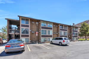 View of property with uncovered parking and a mountain view
