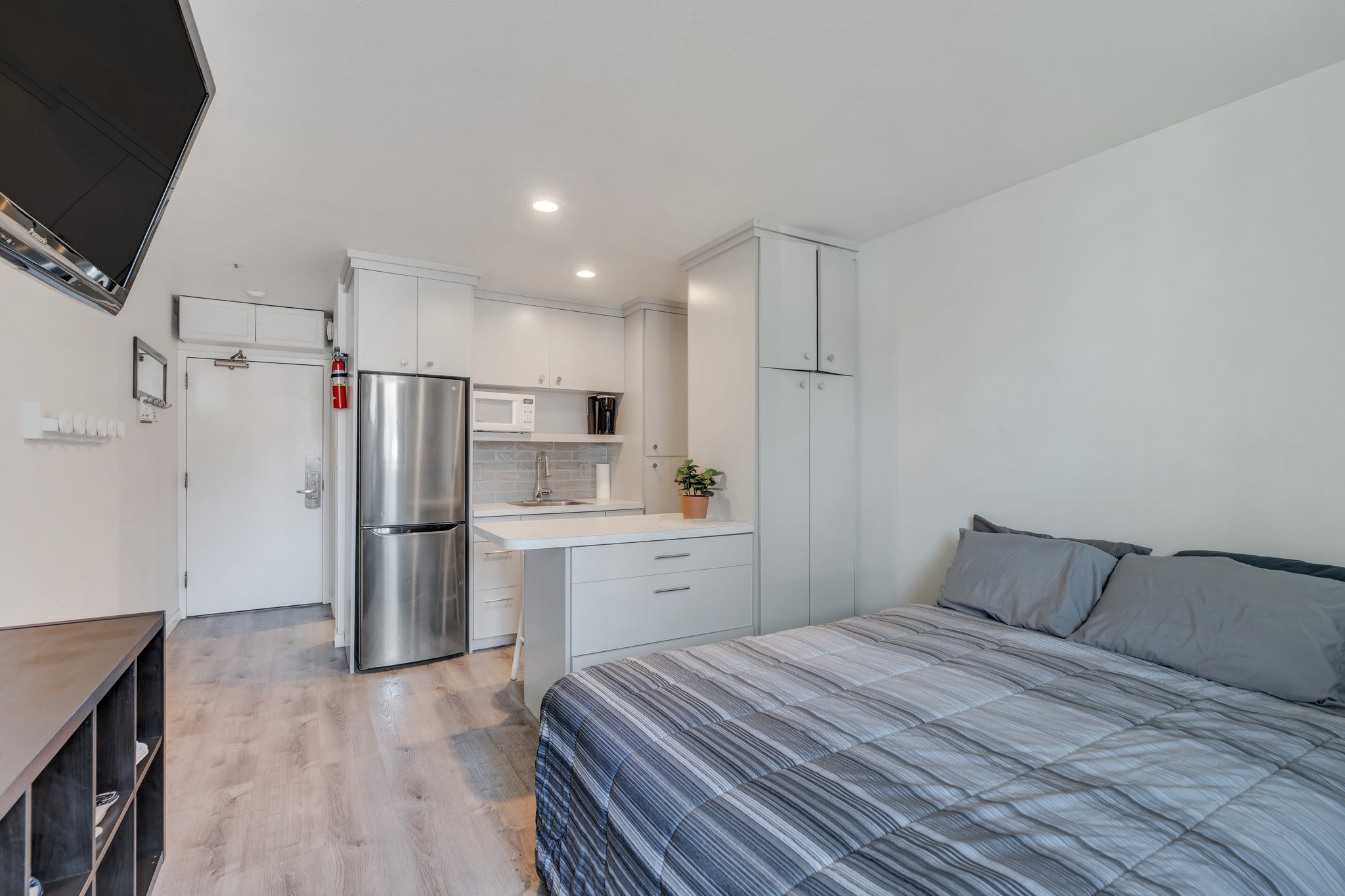 Bedroom with recessed lighting, light wood-style flooring, a sink, and freestanding refrigerator