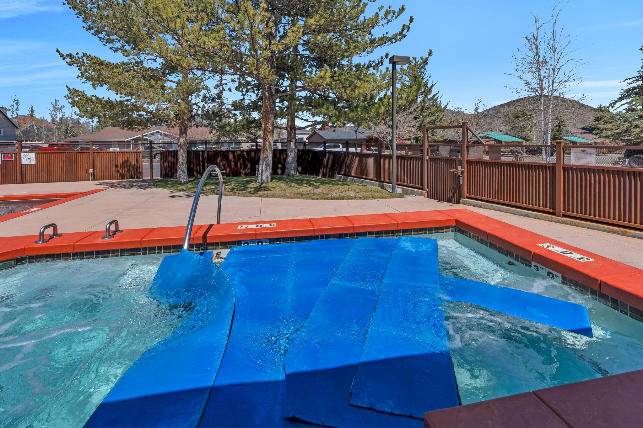 Community pool with a fenced backyard