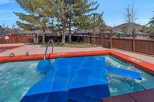 Community pool with a fenced backyard