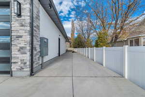 View of home's exterior with stone siding, stucco siding, and a patio area