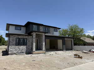 Contemporary home featuring a garage and stone siding