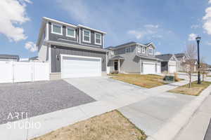 View of front of property featuring a gate, fence, concrete driveway, an attached garage, and board and batten siding