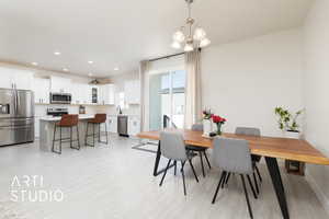 Dining space with light wood finished floors, recessed lighting, and a chandelier