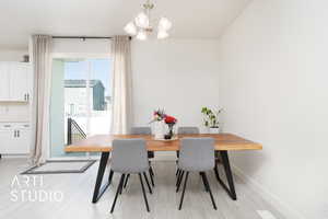 Dining space with an inviting chandelier, light wood-style floors, and baseboards