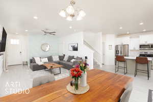 Dining area with recessed lighting, stairway, light wood-type flooring, and ceiling fan with notable chandelier